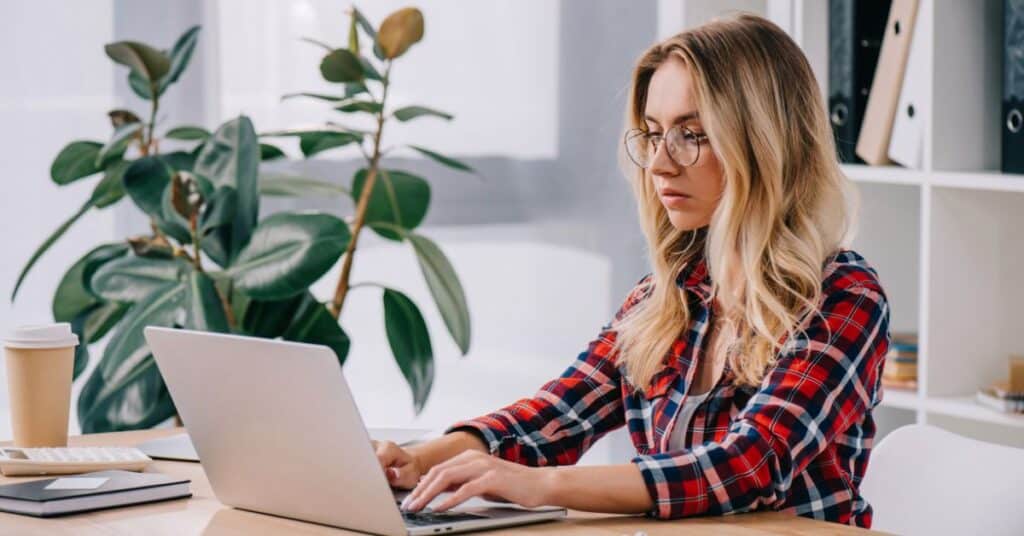 Focused business woman using laptop while taking part in webinar